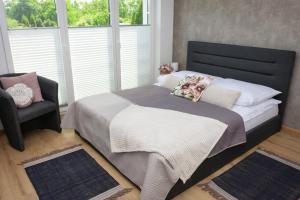 sypialnia z łóżkiem z krzesłem i oknem w obiekcie Apartamenty Legionów 30 w Oświęcimiu