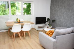 sala de estar con sofá, mesa y sillas en Apartamenty Legionów 30 en Oświęcim