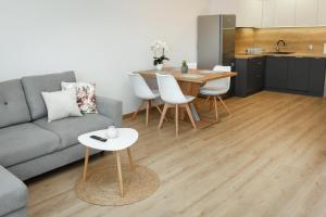 salon z kanapą i stołem oraz kuchnia w obiekcie Apartamenty Legionów 30 w Oświęcimiu