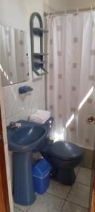 a blue toilet in a bathroom with a shower at Hotel Begonias in Lambayeque