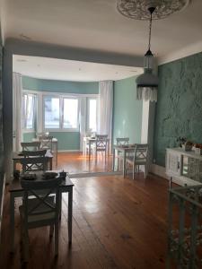sala de estar con suelo de madera, mesas y sillas en Godinho's House, en Matosinhos