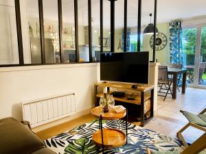 salon z telewizorem z płaskim ekranem na stole w obiekcie Reine Bow - YourHostHelper w mieście Trouville-sur-Mer