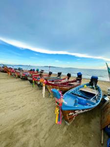 a row of boats lined up on the beach at Beach Gallery House in Jomtien Beach