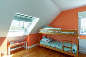 una camera da letto con pareti arancioni e letti a castello di Ker Ar Men a Porspoder