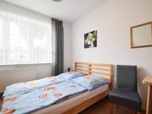 1 dormitorio con 1 cama, 1 silla y 1 ventana en Dom Pod Sosnami, en Mielno