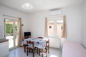 Zimmer mit einem Tisch mit Stühlen und einem Bett in der Unterkunft Casa Michelina - Goelba in San Mamiliano