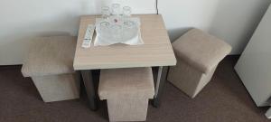 a wooden table with two chairs and a table with two controllers at Vila Iulia in Baile Unu Mai