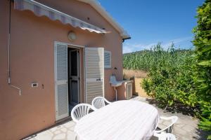 eine Terrasse mit einem Tisch und Stühlen neben einem Haus in der Unterkunft Casa Michelina - Goelba in San Mamiliano