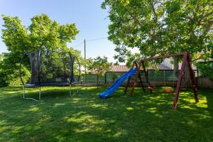 a playground with two swings and a slide at Villa Anavi in Bičići