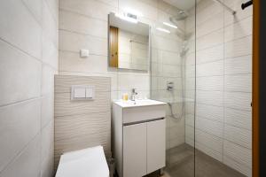 La salle de bains blanche est pourvue d'un lavabo et d'une douche. dans l'établissement Ville Imperial Vodice, à Vodice