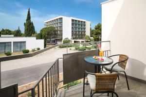 a balcony with a table and chairs and a building at Ville Imperial Vodice in Vodice