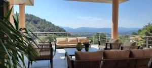 a balcony with chairs and tables and a view of mountains at Les Hauts du Peireguier in La Motte