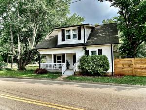 a small white house on the side of a street at Hip & Spacious 3BR w/ FirePit & Large Yard in Knoxville