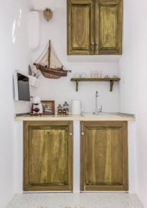 a kitchen with wooden cabinets and a sink at Koufiakas boathouse in Pollonia