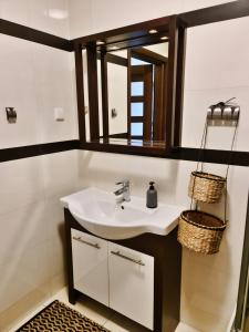La salle de bains est pourvue d'un lavabo et d'un miroir. dans l'établissement Portowy - Sweet House, à Świnoujście