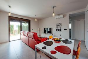 sala de estar con mesa y sofá en Casita Rosa en Alicante