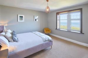 シーハウシズにあるHost & Stay - The Puffins Nestのベッドルーム1室(ベッド1台、海の景色を望む窓付)が備わります。