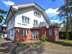 a large white and red brick house with at Dom Pod Sosnami in Mielno