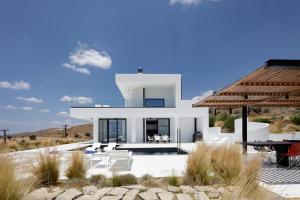 a white house with a pool and a table at White Hera in Agios Pavlos