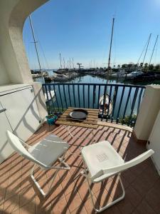 2 chaises et une table sur un balcon avec port de plaisance dans l'établissement Vista mare, à Misano Adriatico
