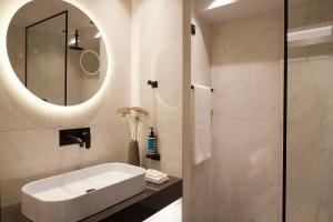 a bathroom with a white sink and a mirror at Teight Hotel in Thessaloniki
