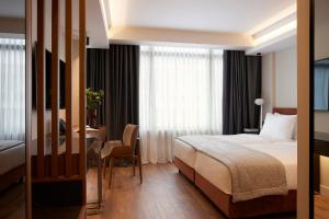 a hotel room with a bed and a table and a desk at Teight Hotel in Thessaloniki