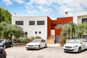 zwei Autos, die vor einem Haus geparkt sind in der Unterkunft Alvorférias Premium in Alvor