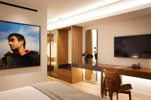 a bedroom with a tv and a desk and a bed at Teight Hotel in Thessaloniki