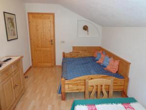 1 dormitorio con cama de madera y mesa de madera en Sterzingerhof, en Neustift im Stubaital