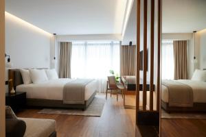 a hotel room with two beds and a desk at Teight Hotel in Thessaloniki