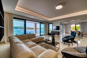 a living room with a large couch and a view of the ocean at Villas Anita in Veli Iž