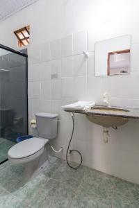 um banheiro com vaso sanitário e pia em Pousada Flor do Dendê em Arraial d'Ajuda