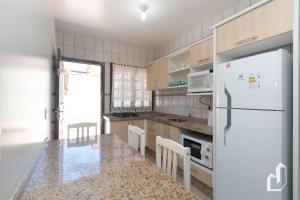a kitchen with a refrigerator and a counter top at Casa térrea com 03 dormitórios perfeita para seus dias de férias na praia in Bombinhas