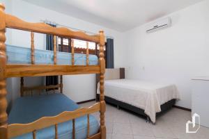 a bedroom with two bunk beds and a bed at Casa térrea com 03 dormitórios perfeita para seus dias de férias na praia in Bombinhas