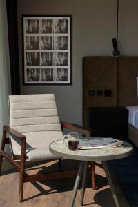 a living room with a chair and a table with a drink on it at Teight Hotel in Thessaloniki