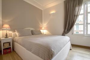 a white bedroom with a large bed and a window at Alassio bnb Apartments in Alassio