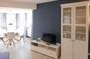 ein Wohnzimmer mit einem TV auf einem weißen Schrank in der Unterkunft Strandburg Juist - Turmwohnung 105 (Ref. 50957) in Juist