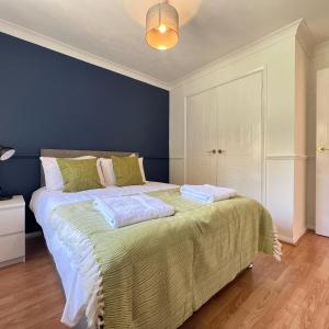 ein Schlafzimmer mit einem großen Bett mit blauer Wand in der Unterkunft Large 4 Bed House - 2 Bathrooms With Parking - Ipswich in Nacton