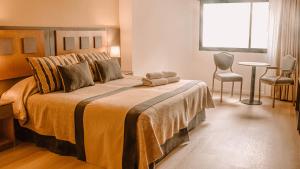 1 dormitorio con 1 cama grande y 1 mesa en Hotel Tronador en Mar del Plata
