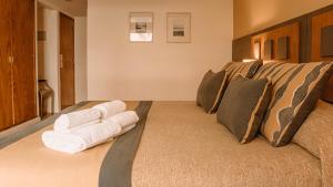 Habitación con sofá y 3 almohadas. en Hotel Tronador en Mar del Plata