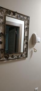 a mirror on a wall with a roll of toilet paper at Tajna037 in Kruševac