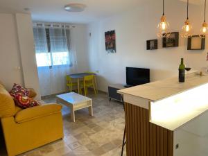 a living room with a yellow chair and a kitchen at Apartamento El Azul in Molina de Segura