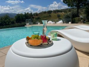 a plate of fruit on a table next to a pool at Villa Greco in Rossano