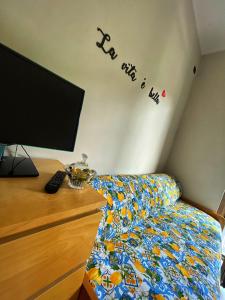 Schlafzimmer mit einem TV, einem Bett und einem Schreibtisch in der Unterkunft B&B L'agrumeto in Nocera Inferiore