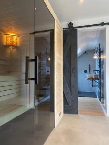 a bathroom with a glass door and a sink at Nordic Huus in Butjadingen