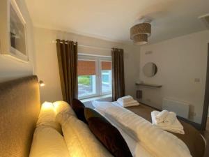 a bedroom with a large bed with a window at Location Location - Gorgeous 3 Bed Apartment in Killarney in Killarney