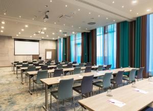 una sala de conferencias con mesas y sillas y una pantalla de proyección en Hyatt Place Toronto-Brampton, en Brampton