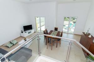 a living room with a glass railing and a dining table at Casa Ferreira Encosta dos Salgados - By Dalma Portuguesa in Albufeira