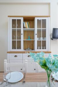 a kitchen with a white cabinet and a table at Anna's House in Xerokampos