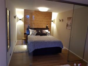 Schlafzimmer mit einem Bett mit einem Kopfteil aus Holz in der Unterkunft ALMI - Alpenglück Traumhafte Whg.m.20qm Dachterr. in Oberstaufen
